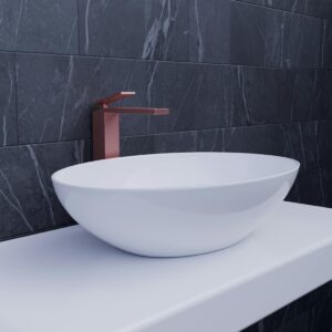 Elegant white sink with copper faucet against a dark marble wall adds a touch of modern luxury.